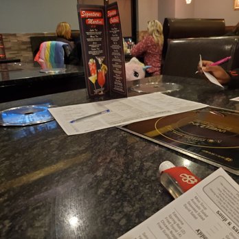 Kintaro Sushi & Hot Pot - a woman sitting at a table with a menu in front of her - Japanese Near Me - Brooklyn, Ohio Kintaro Sushi & Hot Pot - a woman sitting at a table with a menu in front of her - Japanese Near Me - Brooklyn, Ohio