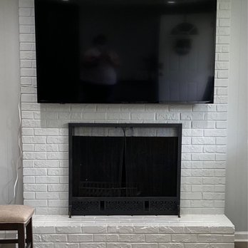 DR Handy Services - TV with full motion mount on a brick fireplace - Handyman Near Me