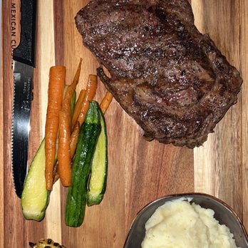 Santo Placer - a steak, mashed potatoes, carrots, and corn on a cutting board - Steakhouses Near Me - San Diego, California Santo Placer - a steak, mashed potatoes, carrots, and corn on a cutting board - Steakhouses Near Me - San Diego, California