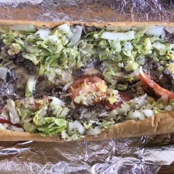 The Sub Shoppe - 14. Cheese Steak Hoagie - A cheesesteak hoagie with shredded lettuce, sliced tomatoes, and cooked beef in a long sandwich bun, served on aluminum foil. - Pizza Near Me - Maple Shade, New Jersey
