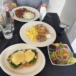 Lobster Benedict with a side salad, cranberry orange muffin, French toast with scrambled eggs and chicken, sausage, and jerk chicken dinner.