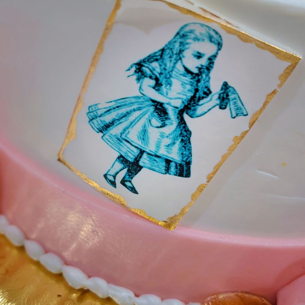 Elite Cakes - a cake decorated with a picture of alice and the mad hatter - Custom Cakes Near Me - El Paso, Texas