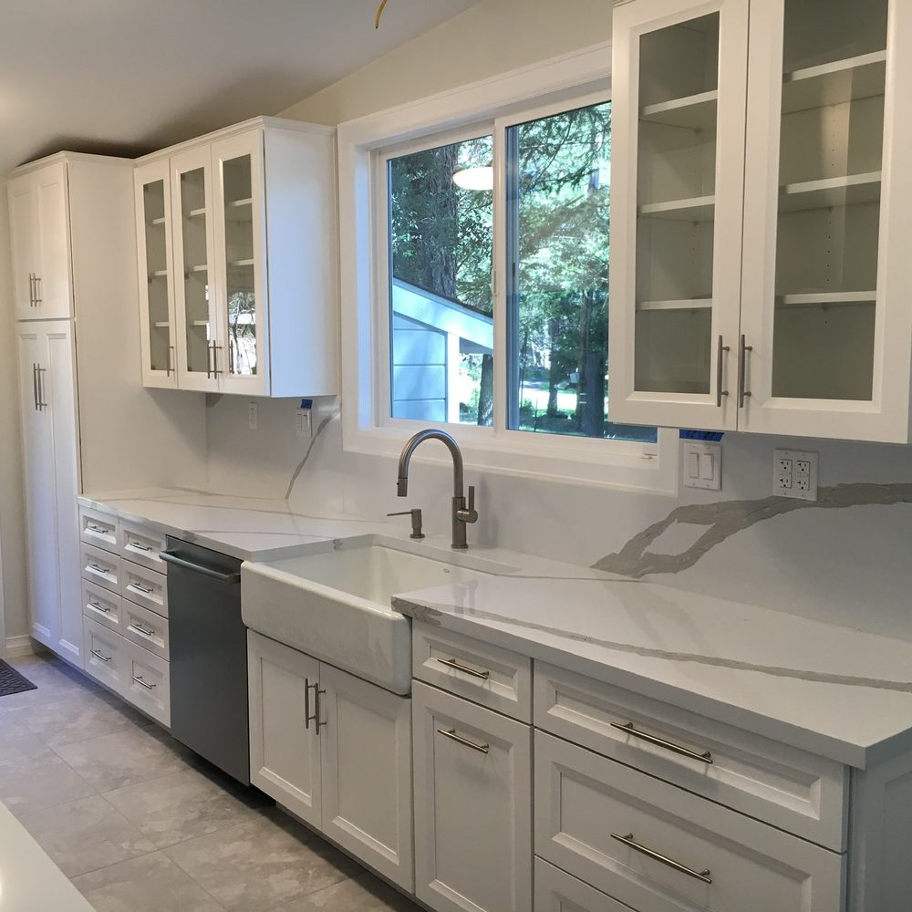 ZV Construction - a kitchen with white cabinets and stainless steel appliances - Flooring Near Me - Napa, California