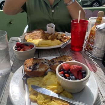 Johnny's Luncheonette - Grilled blueberry muffin, scrambled eggs, fruit. Challah French toast and home fries in background - Diners Near Me - Newton, Massachusetts