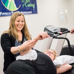 Saunders Therapy Centers - Occupational therapist assisting with shoulder exercise in Maple Grove clinic's gym.