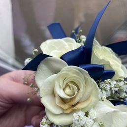 White roses corsage with blue ribbon