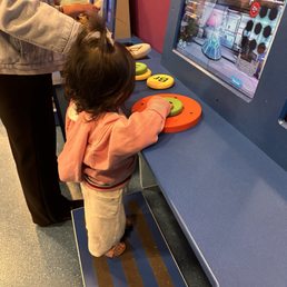 exploring a hands-on game station at the museum.