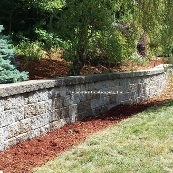 Innovative Landscaping - a retaining wall in a backyard - Lawn Services Near Me - Acton, Massachusetts