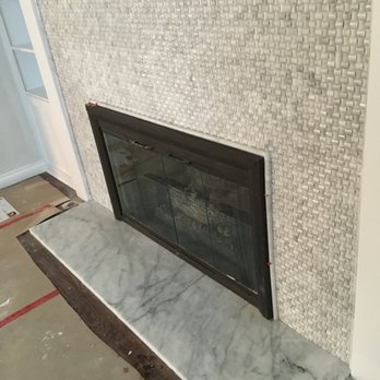 Kavo Renovations - a fireplace with a tile surround - Carpenters Near Me - Vancouver, British Columbia Kavo Renovations - a fireplace with a tile surround - Carpenters Near Me - Vancouver, British Columbia