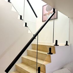 LA Railings - Modern indoor glass railing with matte black spigots -- sleek safety solution for staircases and landings in Los Angeles homes.