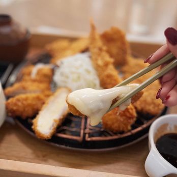 Saku - a person holding chopsticks over a plate of food - Japanese Near Me - Vancouver, British Columbia Saku - a person holding chopsticks over a plate of food - Japanese Near Me - Vancouver, British Columbia