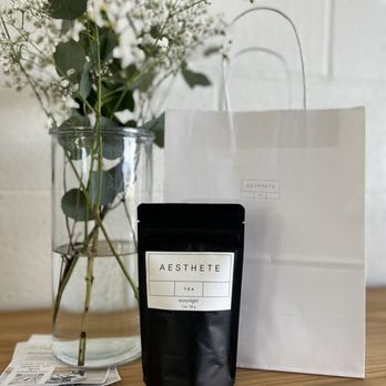 Aesthete - a bag of tea next to a vase of flowers - Coffee & Tea Near Me