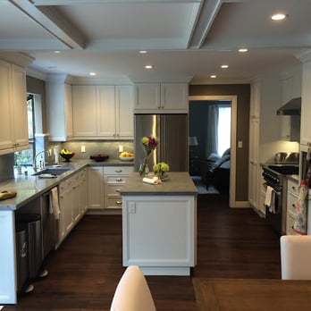 JSE Custom Builders - a kitchen with white cabinets and wood floors - General Contractors Near Me - Half Moon Bay, California