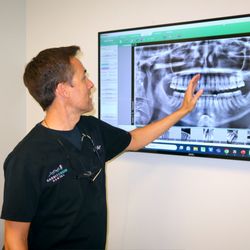 Dr. Joseph Gegzna reviewing digital X-rays with a patient at Rabbit Creek Dental in Mobile, AL