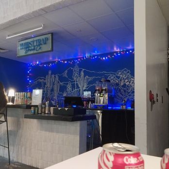 The Insider - A beverage counter with a desert-themed mural and string lights is visible, with soda cans and a Coca-Cola can in the foreground. - Pizza Near Me - Mobile, Alabama