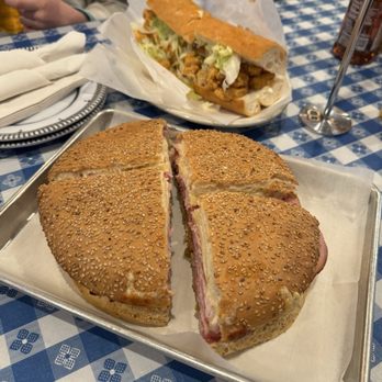 Francesca by Katie's - A full muffaletta in the foreground and a full shrimp Poboy in the rear - Pizza Near Me - New Orleans, Louisiana