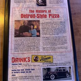 Menu, spicey green beans, onion rings, all meat Detroit style pizza and in and out burger. - The menu page displays sections for desserts, drinks, and the history of Detroit-style pizza. It features a photo of two people with a pizza, a vintage car image, and a logo for Vernor's Ginger Ale. The dessert section mentions a fudge brownie and PiZookie, while the drinks section lists fountain soda, bottled root beer, orange Fanta, and ginger ale. The history section provides background on the restaurant's origins, with a focus on its Detroit-style pizza and its connection to local history. The layout includes images, text, and branding elements, all set against a background map.