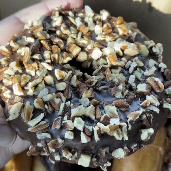 Johnson's Bakery - a hand holding a chocolate covered donut - Donuts Near Me - Perry, Florida Johnson's Bakery - a hand holding a chocolate covered donut - Donuts Near Me - Perry, Florida