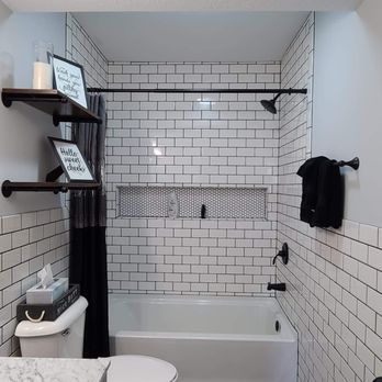 Built by Wolff - a white tiled bathroom with a black shower curtain - General Contractors Near Me