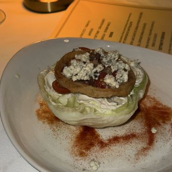 Daniel’s - FARMER MIKE'S ICEBERG WEDGE SALAD Crispy Onions, Bacon, Tomatoes, Valdeon Blue Cheese Dressing - Steakhouses Near Me - Coral Gables, Florida