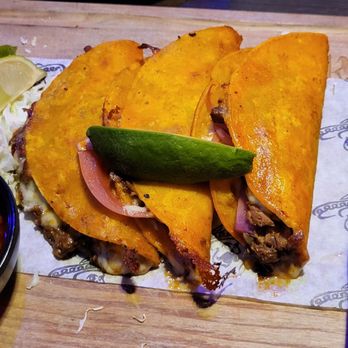 Kalaveras - QUESA BIRRIA TACOS: 3 crispy cheese tacos - slow braised beef - lime onions - avocado - cilantro - consommé - Mexican Near Me - Orange, California Kalaveras - QUESA BIRRIA TACOS: 3 crispy cheese tacos - slow braised beef - lime onions - avocado - cilantro - consommé - Mexican Near Me - Orange, California