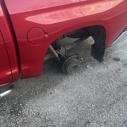 Toyota Tundra on the side of the road without wheel.