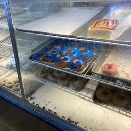 Crumbs at the bottom of the donut case.