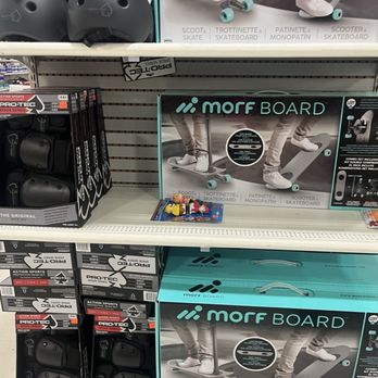 Marden's - 06/17/2025 - The image shows retail store shelves stocked with Morf Board skateboards in boxes, along with protective helmets placed on the top shelf. The skateboard packaging displays images of children using the boards, and the boxes include product details. The helmets are black and positioned on the upper shelf, with additional skateboard accessories visible nearby. - Discount Store Near Me - Biddeford, Maine
