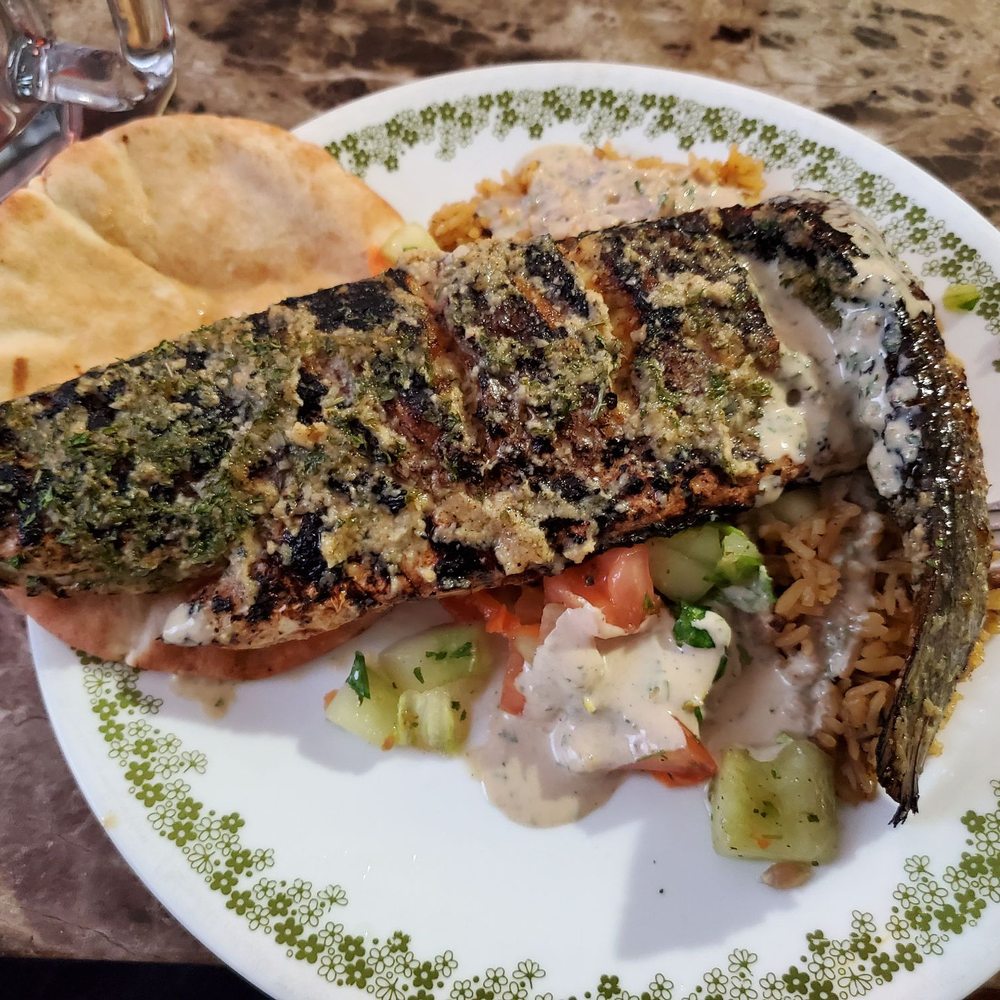 Blackened branzino atop rice, tomato/cucumber/mint, and pita with tahini