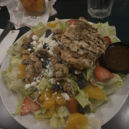 Nuts and berries salad topped with grilled chicken with balsamic dressing