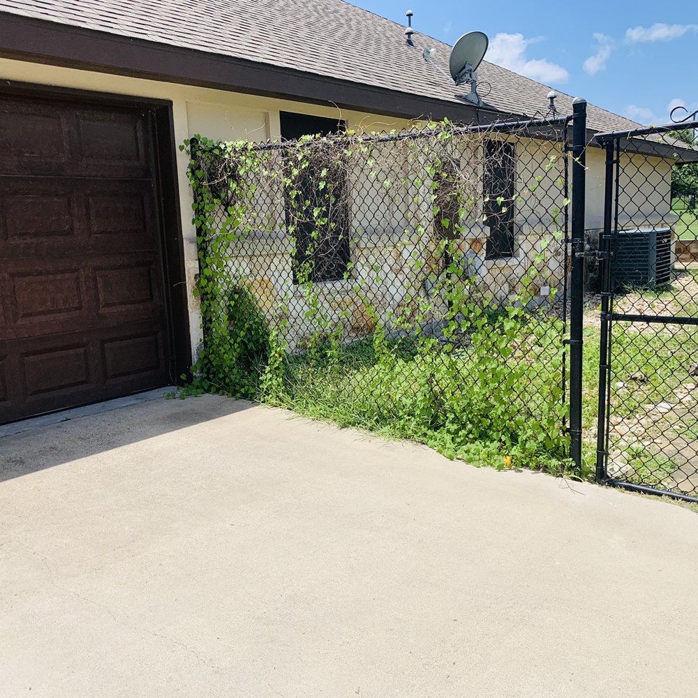 Liberty Lawn Care - a fenced yard with a garage - Landscaping Near Me