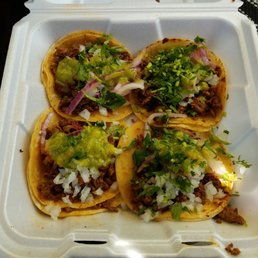 four tacos in a styrofoam container