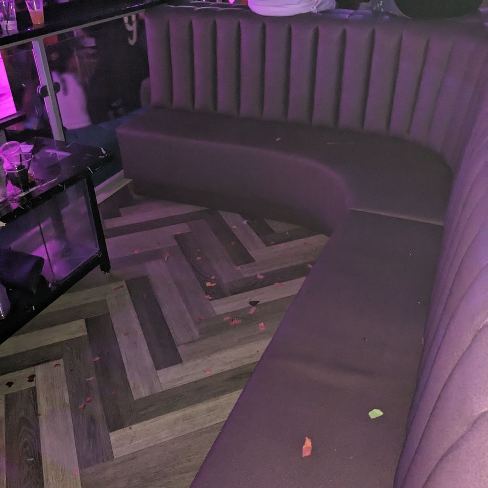 Encore Nightclub - a purple couch with a tv in the corner - Bars Near Me - Charlotte, North Carolina