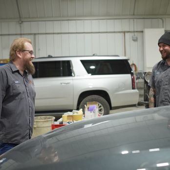 Quimbys Collision Center - two workers smiling in a body shop - Body Shops Near Me - Kasson, Minnesota Quimbys Collision Center - two workers smiling in a body shop - Body Shops Near Me - Kasson, Minnesota
