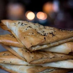 Roni's Kitchen - Burekas- vegan almond-feta, eggplant, mint & za'tar. Served with tahini, housemade pickled veggies, Schug and House Salad or Quinoa Tabouli.