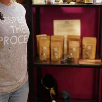 Teas With Meaning - a woman standing in front of a shelf - Tea Rooms Near Me Teas With Meaning - a woman standing in front of a shelf - Tea Rooms Near Me