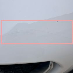 QuikWash - Encino - The paint has cracked under pressure. The bumper flexed during the impact, causing the paint layer to break