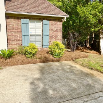 Lawn Masters Landscape - a brick house with blue shutters - Lawn Services Near Me