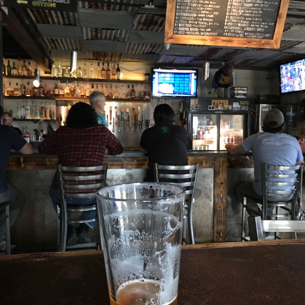 a glass of beer sitting on a bar a glass of beer sitting on a bar