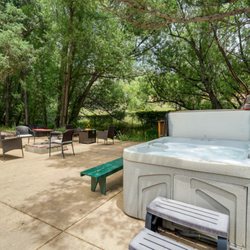 Blue Spruce Caboose - Back patio with hot tub, creek and fire pit -- accessible to rentals