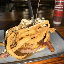 Twisted Root Burger - THE MILLIONAIRE Open-faced burger w/ wagyu, cheddar, truffle aioli, garlic mushrooms, bacon, dark beer sauce, crispy fried onion strings.