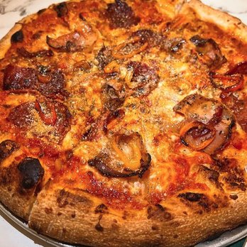 Mattarello - A pizza featuring a thick, baked crust with a layer of melted cheese, topped with sliced mushrooms and pepperoni. The pizza is presented on a metal tray, with a marble surface visible in the background. - Italian Near Me - Markham, Ontario