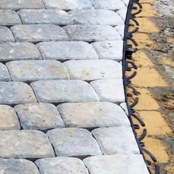 Solid Rock Lawn & Landscape - After the cuts we have installed flexible paver restraint to hold the stones in place for years to come.