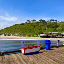 Malibu Pier - A little boat and a blue garbage can.