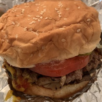 Five Guys - A little burger!!  Mighty filling!! - A cheeseburger with a sesame seed bun, tomato slice, lettuce, and beef patty wrapped in foil, served in a casual setting. - Burgers Near Me - Bayside, New York
