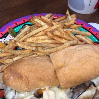 De Beque Country Store - I had the Philly Cheesesteak with onions, mushrooms, and onions! - A sandwich with melted cheese and grilled meat, served with French fries and a soda in a restaurant setting. - Delis Near Me - De Beque, Colorado