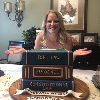 Cake Barn - Graduate in front of her custom made law school book cake. - Bakeries Near Me