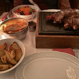 florentine steak chianina, sides of salad and roasted potatoes florentine steak chianina, sides of salad and roasted potatoes