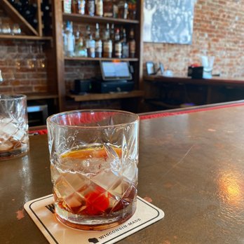 Brick Sip Haus - a glass of alcohol on a coaster - Wine Bars Near Me - Tomah, Wisconsin