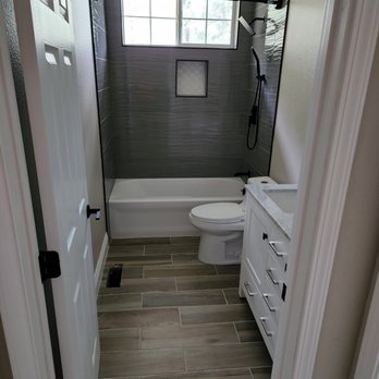 First Call Construction - a bathroom with a tub, toilet, and sink - Roofing Near Me First Call Construction - a bathroom with a tub, toilet, and sink - Roofing Near Me